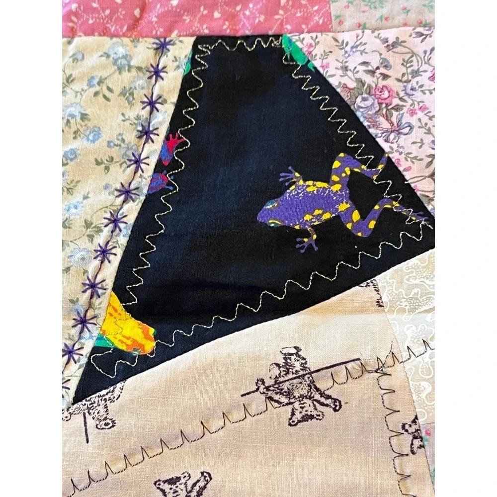 Black quilted wall hanging featuring colorful frogs 29x29